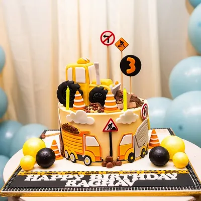 This construction-themed cake is a work of art, complete with edible trucks, traffic signs, and chocolate "dirt," perfectly matching the party's decor.