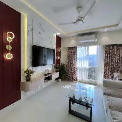 A stunning living room in Andheri, where deep burgundy tones and marble textures create a sense of modern opulence. The custom TV unit and ambient lighting make this the perfect space for both relaxing and entertaining.