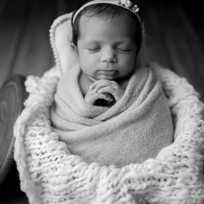 A classic black and white conversion of a basket pose. It creates a dramatic and artistic portrait, focusing on the baby's form and peaceful expression.