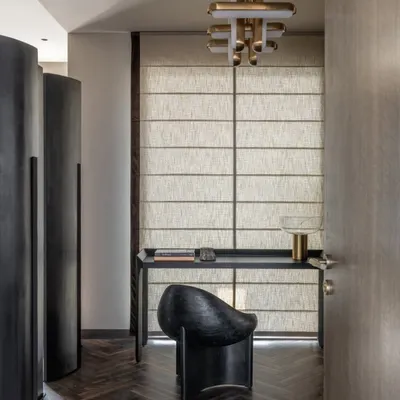 A glimpse into a study nook in the Aikaa villa. The sculptural black chair, minimalist desk, and elegant brass lighting create a workspace that is both functional and highly stylish.