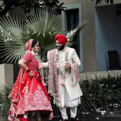 A fun and playful moment between the Sikh bride and groom. Her dynamic pose and his smiling reaction create a candid and joyful portrait that perfectly captures their personalities.
