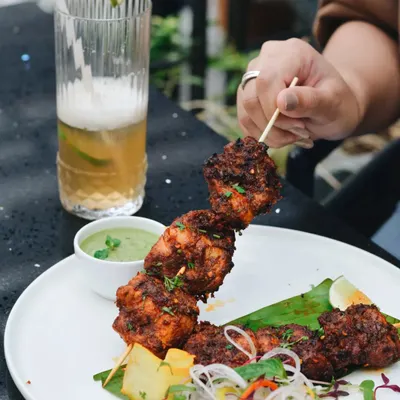 Capturing people with food is one of my favorite genres. This shot of a person holding a chicken skewer at a restaurant table brings the dish to life and creates a relatable, happy moment.