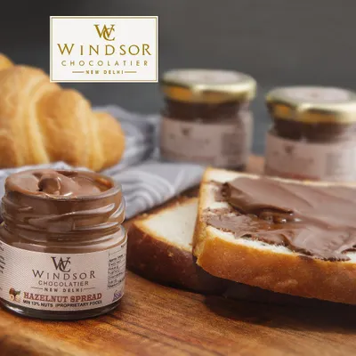 Our Hazelnut Spread is perfect for more than just toast. Here it is shown with fresh bread and a croissant, illustrating its use as a delicious, high quality spread for cafes and bakeries.