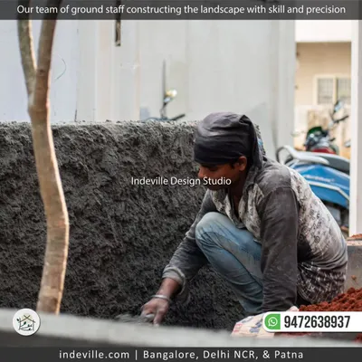 Here is a member of my ground staff meticulously applying plaster to a landscape wall. This image shows the focus and skill that goes into every step of the construction process, ensuring a high-quality finish.