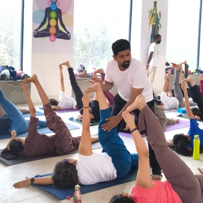 A moment from our soulful yoga retreat in Rishikesh. Here, our instructor gives a hands-on adjustment, ensuring each participant gets personalized attention even in a group setting.
