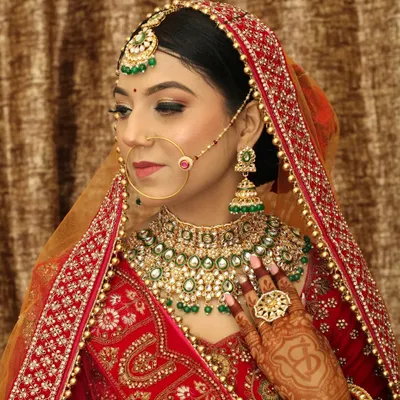 A classic three-quarter bridal portrait, showcasing the complete look from her elaborate dupatta to the henna on her hands. This is a must-have traditional wedding shot for the family album.