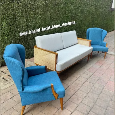 This living room set combines a cane-panelled sofa with two classic high-back wing chairs, all in a cohesive mid-century style. I can customize the fabric and wood finish, as shown here with the pairing of neutral and bold blue upholstery.