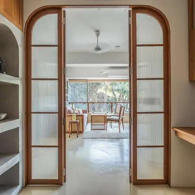 A view from the workspace into the consultation area of the nutrition clinic. The arched, fluted glass doors create a beautiful transition between the two zones while maintaining a sense of openness and light.