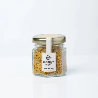 A clear, front-facing shot of a jar of Honey Hut Bee Pollen on a pure white background. This is a perfect example of an Amazon-ready primary product image.