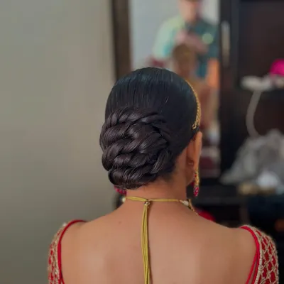 This is a clean, sleek, and intricately twisted bun. This style is perfect for a bride who wants a polished and sophisticated look for her wedding day. The sleek finish ensures there are no flyaways.