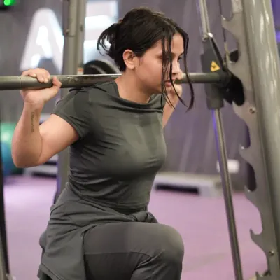 This client performs a lunge on the Smith machine, a great exercise for building leg strength and stability with added support.