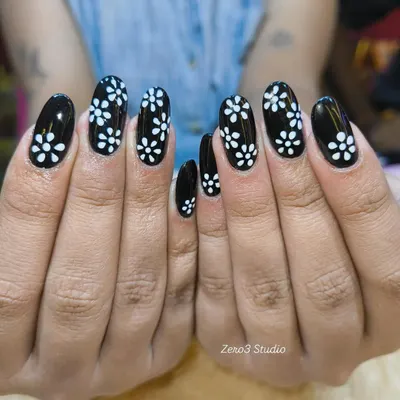 A classic black and white combination with a delicate floral pattern. This hand-painted design on glossy black gel polish offers a chic and timeless look for any occasion.