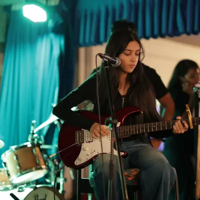 Focused and in the zone. A student guitarist nails her part during our annual Rhapsody in Radiance showcase. We prepare our students not just to play, but to perform with stage presence.