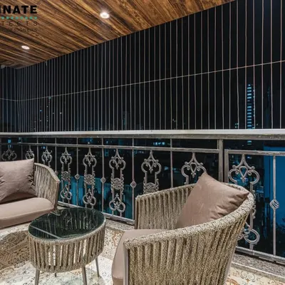 A beautifully designed balcony in Seawoods, perfect for enjoying an evening. The space features comfortable wicker chairs, a wood-paneled ceiling, and an ornate metal railing, turning a simple balcony into a private retreat.