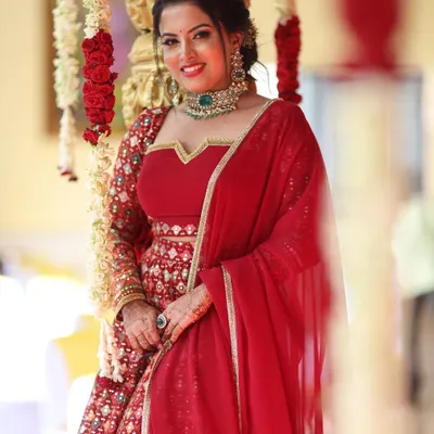 A closer look at the rich red reception lehenga, highlighting the detailed embroidery and flattering fit.