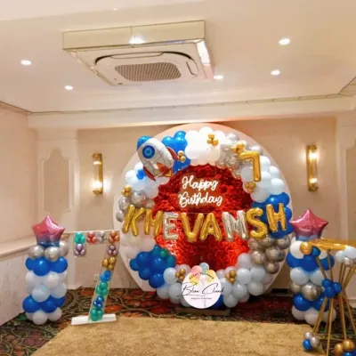 An outer space themed birthday party for a 7th birthday. We created this balloon ring with a red foil backdrop, a rocket ship balloon, and a marquee number '7'.