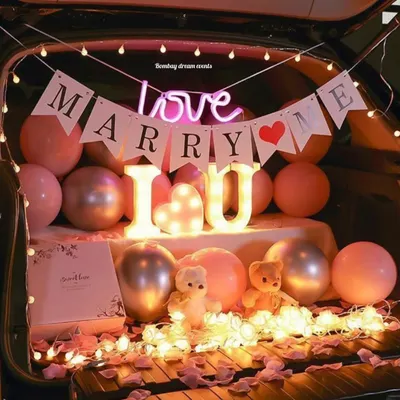A romantic "Marry Me" car trunk proposal setup. This design uses marquee letters spelling "I ❤️ U", a "Marry Me" banner, a "love" neon sign, and soft lighting for a truly memorable surprise.