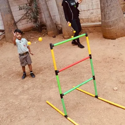 A young student practices his aim with a fun ladder toss game. This activity is excellent for developing hand-eye coordination and learning to control force and trajectory.