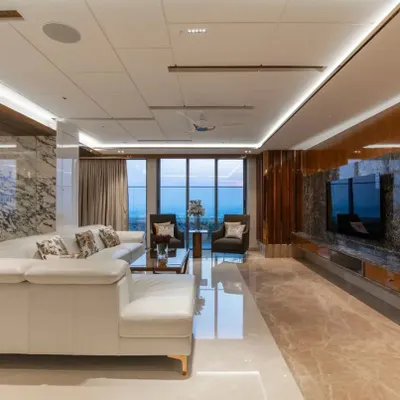 The living room of the TATA Promont penthouse in Bangalore, designed to maximize the spectacular city views. The open-plan layout, reflective marble flooring, and neutral color palette ensure that the skyline is always the star of the show.