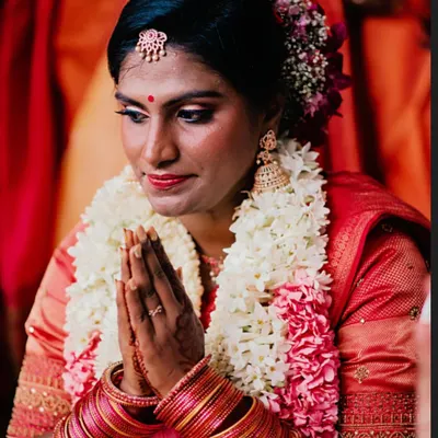 A serene moment of a South Indian bride during her Muhurtham ceremony. I created a cut crease eye with golden and pink shimmer to complement her traditional red saree, focusing on a radiant finish for her brown skin.