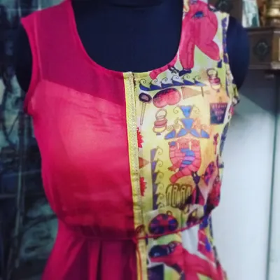 I love to experiment with fusion designs. This dress combines a solid pink georgette with a quirky, colorful printed fabric, creating a playful and modern Indo-Western piece that is truly unique.