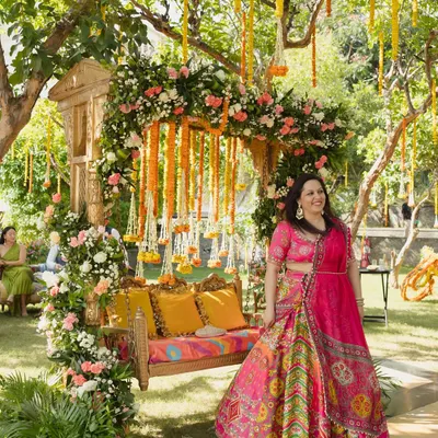 A beautiful photo from a garden Mehendi, where I designed a traditional wooden swing (jhoola) completely covered in pink and white roses with hanging marigold strings.