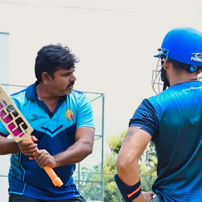 Our coaches, like Vijay Madyalkar, provide hands-on guidance to players at every level. Here, he demonstrates the correct bat grip and stance to a student.