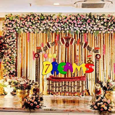 For this naming ceremony, I created a grand stage with a full floral arch using premium pink and white flowers. The setup includes a beautifully decorated cradle as the centerpiece, elegant drapery, and lighting to create a memorable event.
