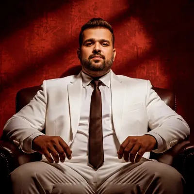 A powerful shot from a digital magazine photoshoot. The classic white suit and dramatic lighting create a timeless look.