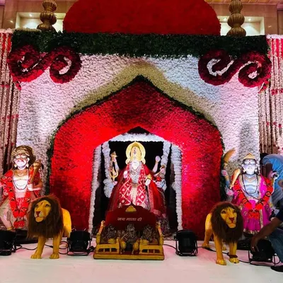 A grand backdrop I created for a Mata ki Chowki. The central arch, made of red and white flowers, perfectly frames the deity's idol, creating a divine throne. The entire setup is designed to be a powerful and beautiful focal point for the prayers.