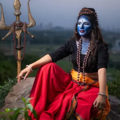 A full shot of the Lord Shiva inspired look, showing how the makeup, hair, and styling come together. The blue body paint, Rudraksha beads, and traditional attire create a complete and authentic character for this cinematic shoot.