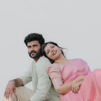 A serene moment for the couple, sitting back-to-back in a field with a clean, bright background. The simplicity of the shot emphasizes their connection.