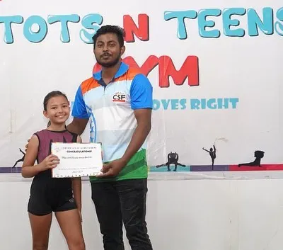 A proud moment. One of our coaches presents a Level 1 certificate to a happy gymnast, celebrating her hard work and achievement.