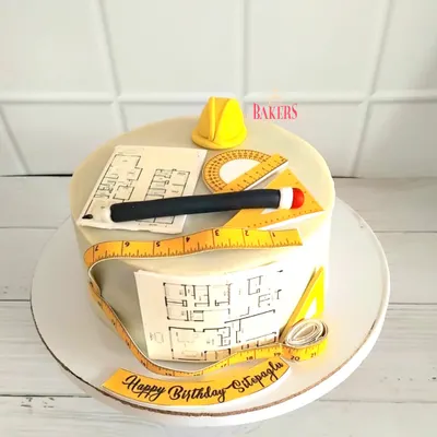 An architect-themed cake for Sitapagl's birthday. This design features edible blueprints, a hard hat, and drafting tools like a protractor and ruler, all handcrafted with great detail.