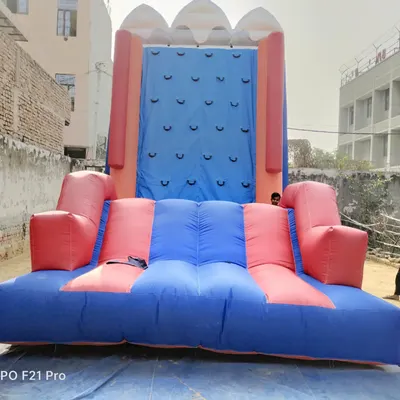 A frontal view of our inflatable climbing wall, measuring 13x28 feet. The structure has a wide, cushioned base for safety and a tall climbing face with sturdy handholds.