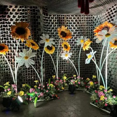A whimsical photo corner featuring giant, illuminated sunflowers. This is a perfect example of how we create unique and playful decor elements for a fun event like a Mehendi or Haldi.