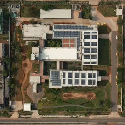 An aerial top-down view of the Fanuc India factory in Chennai. This project won an award for sustainability, incorporating features like extensive solar panels, rainwater harvesting, and green courtyards within the industrial complex.