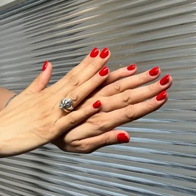 A classic red manicure is always a power move. Here is a set of perfectly shaped, short nails with a vibrant, glossy red gel polish. It’s a timeless look that exudes confidence and style.