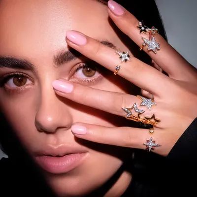 A signature shot from the Farah Khan Atelier campaign, using a creative pose to highlight a stunning collection of star-themed rings. This is what high-end jewellery photography is all about.