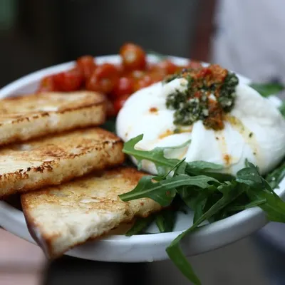 Our house-made burrata served with toasted sourdough bread and sweet, roasted cherry tomatoes. It's simple, fresh, and incredibly delicious.