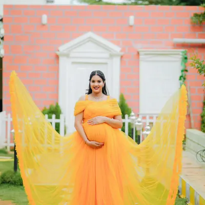 A breathtaking solo portrait with a vibrant yellow gown fanned out to create a stunning visual effect. This shot is all about drama, color, and celebrating motherhood in style.