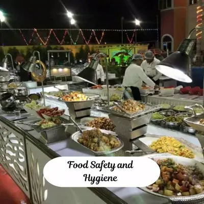Our team ensures food safety and hygiene are top priorities. Here you can see our staff in uniform, managing a well-organized buffet line with proper lighting and serving equipment to maintain quality throughout the event.