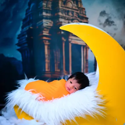 A dreamy newborn photoshoot featuring your little one on a crescent moon prop, set against a magical temple backdrop. I create fantasy scenes to make your baby's first photos truly special.