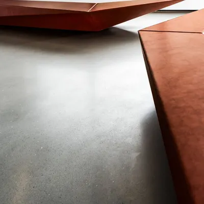 A detail shot of the custom-designed seating in the Parinee Lobby. The sharp, faceted geometry and warm, textured material create a piece that is both a functional bench and a sculptural art form.