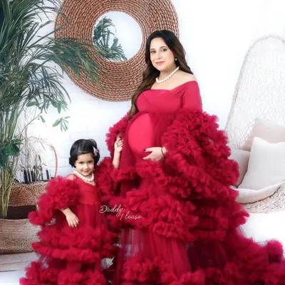 A beautiful maternity portrait of a mother and her daughter in matching ruffled red gowns from my luxury outfit collection. I love capturing the bond between family members as they await their new arrival.