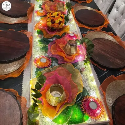 For this festive table, I used a runner of illuminated crystals and layered colorful organza to create a vibrant, glowing centerpiece. The design exudes a celebratory charm, with each hue dancing with joy under the warm lights.