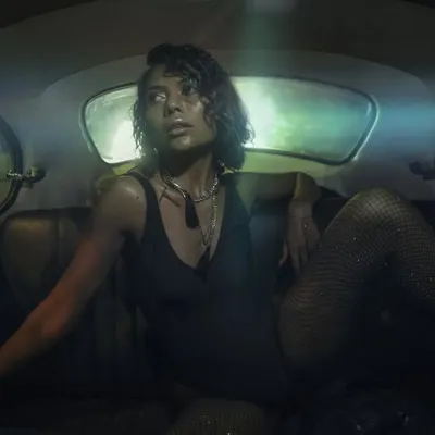 An editorial shot for Twisted Heads Magazine from inside the car. The model's pose and the dark, atmospheric lighting create a sense of unapologetic style and confidence.