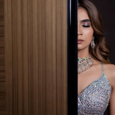 An artistic shot of a glamorous reception look. The focus is on the dramatic smokey eye and contoured cheekbones, creating a high-fashion feel.