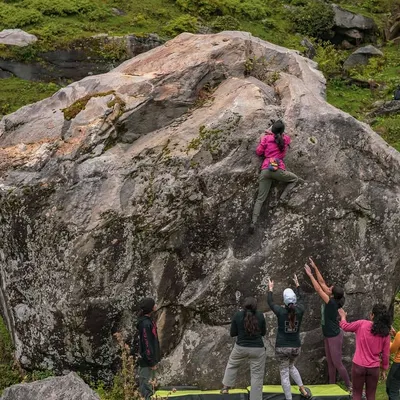A climber takes on a massive boulder during our Sethan retreat. The scale of the landscape is matched only by the determination of our community, with everyone spotting and supporting from below.