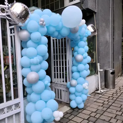 A beautiful balloon arch created for an event entrance. The design uses a soft light blue palette with pops of silver and white, creating a welcoming and elegant entryway for guests.
